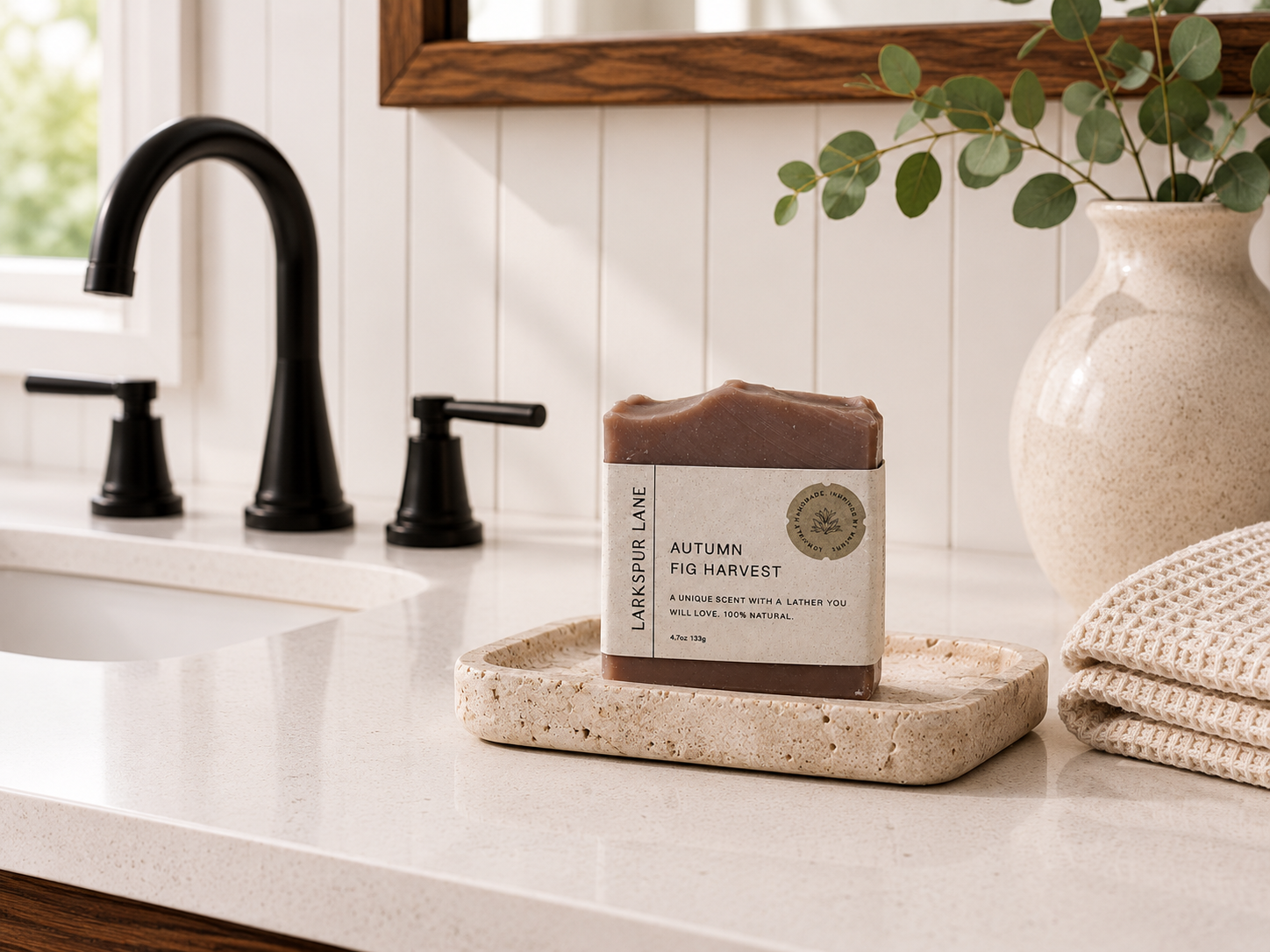 Larkspur Lane Autumn Fig Harvest handcrafted soap displayed on a stone soap dish in a bright modern farmhouse bathroom.