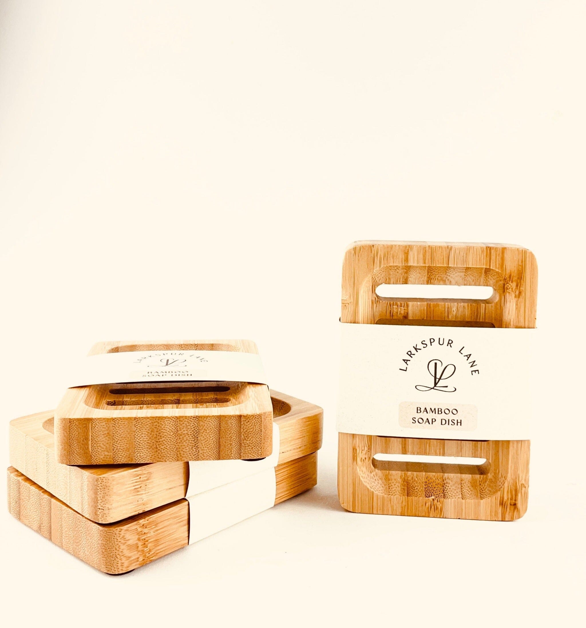 bamboo soap dishes three stacked up one standing on its end all have recyclable paper labels