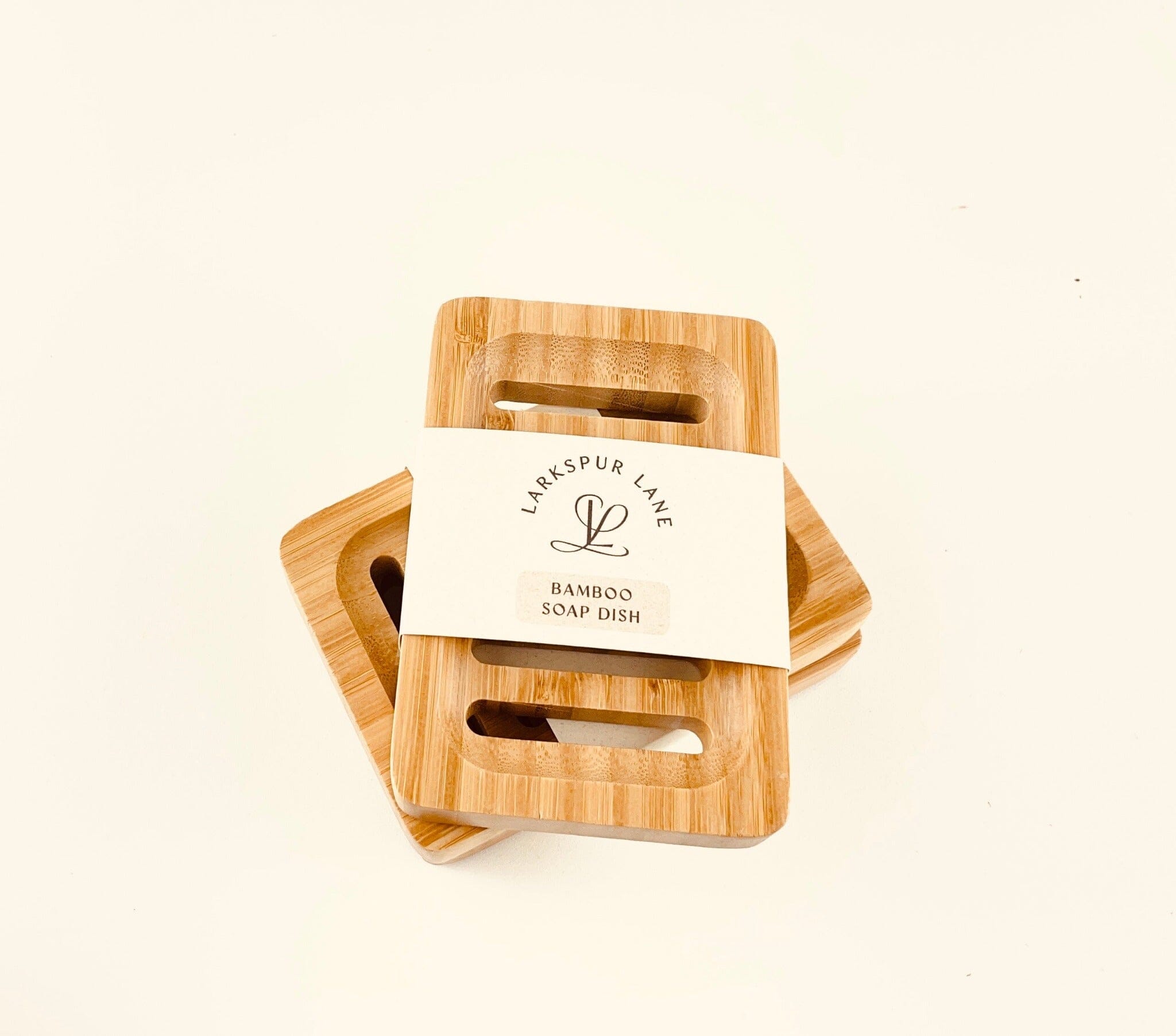 two bamboo soap dishes with recyclable paper labels stacked on each other