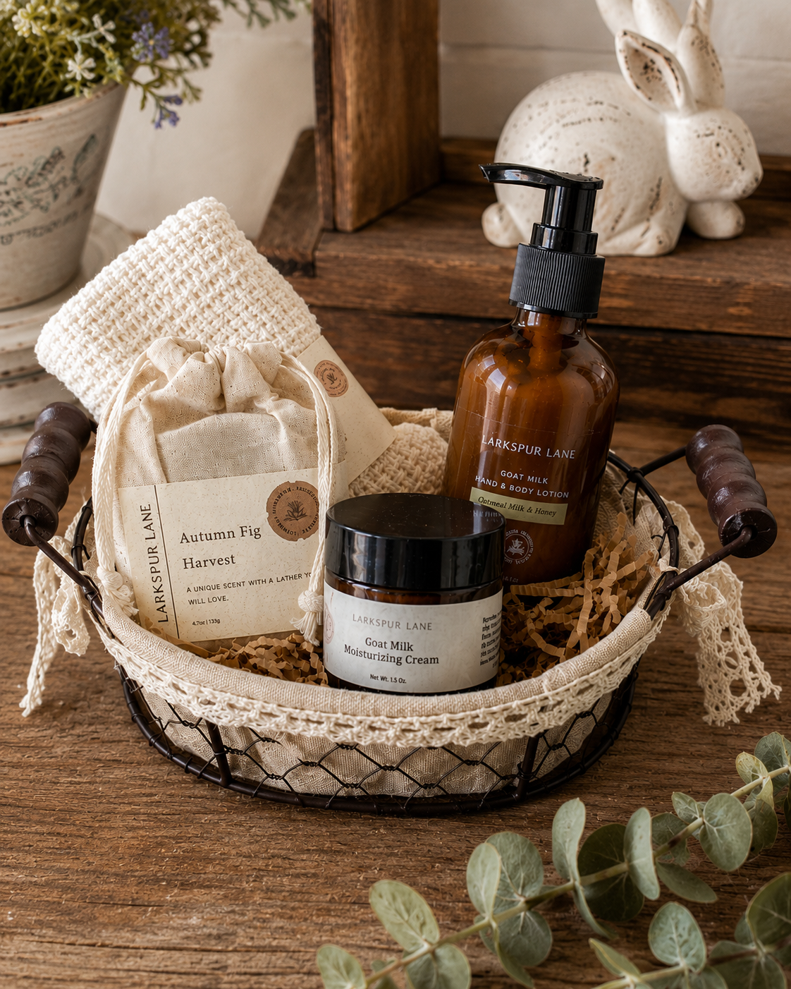 Larkspur Lane Goat Milk Skincare Gift Basket with artisan soap, goat milk lotion, moisturizing cream and cotton washcloth in a rustic wire basket.