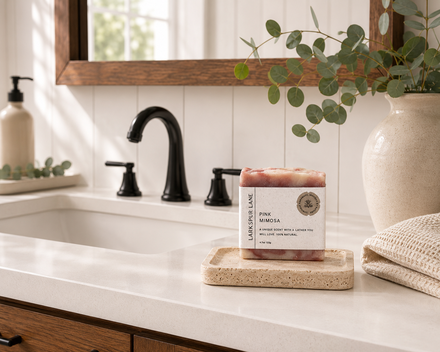 Larkspur Lane Pink Mimosa handcrafted soap displayed on a stone soap dish in a bright modern farmhouse bathroom.